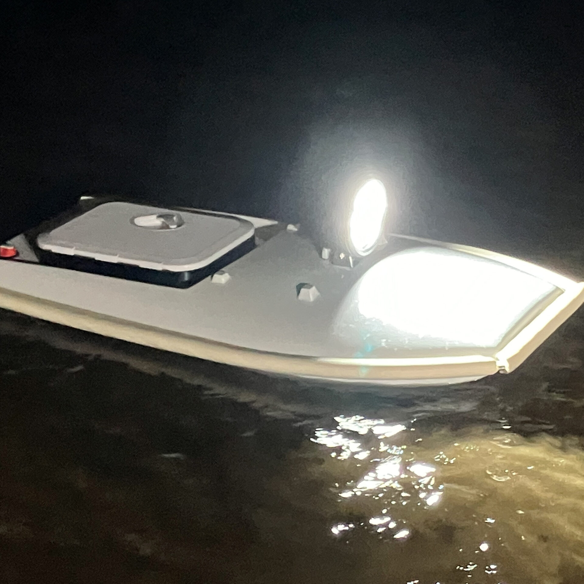 The Lighting on the boat beams a bright light above the water surface.